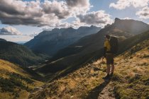 Man wearing a backpack and admiring the high mountains against cloudy sky, Pyrenees, Aragon, Spain — Stock Photo