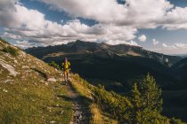 Escursioni uomo con uno zaino contro cime di alta montagna e cielo nuvoloso, Pirenei, Aragona, Spagna — Foto stock