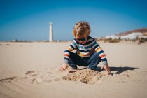 Little kid playing on sand on beach — Stock Photo