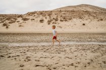 Bambino che gioca sulla sabbia sulla spiaggia — Foto stock
