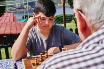 Avô e neto jogando xadrez no jardim — Fotografia de Stock