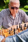 Grandfather and grandson  over chessboard — Stock Photo