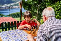 Дедушка и внук за шахматной доской — стоковое фото