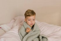 Little boy sitting on sofa at home — Stock Photo