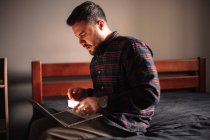 Mann benutzt Laptop und Smartphone zu Hause — Stockfoto
