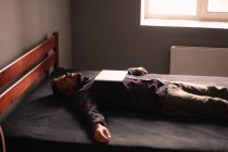 Uomo dormire con il computer portatile sul petto sdraiato sul letto a casa — Foto stock