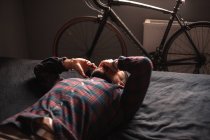 Erschöpfter Mann telefoniert auf Smartphone zu Hause im Bett liegend — Stockfoto