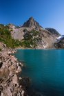 Uma bela paisagem de lago de montanha com rochas e as montanhas — Fotografia de Stock