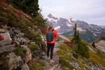 Wanderer mit Rucksack wandern in den Bergen — Stockfoto
