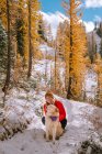 Beautiful girl in winter forest with a dog. — Stock Photo