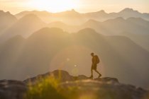 Homme avec sac à dos randonnée dans les montagnes — Photo de stock