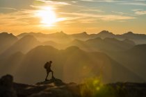 Man with backpack hiking in the mountains — Stock Photo