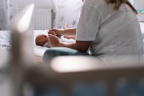 Mãe exercitando os braços de seu bebê. — Fotografia de Stock