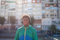 Schwarze Afroamerikaner hören Musik mit Kopfhörern. Hintergrund Wohnungen. — Stockfoto