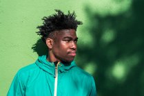 Portrait de garçon noir sérieux sur fond de mur vert. — Photo de stock