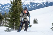 Людина з рюкзаком і лижами в горах — стокове фото