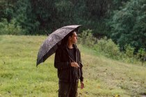 Jeune femme avec parapluie dans le parc — Photo de stock