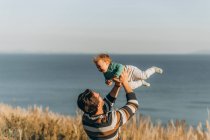 Pai e filho brincando com sua filhinha na praia — Fotografia de Stock