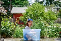 Little girl in a blue dress with a basket of water — Stock Photo