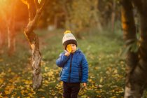 Портрет маленького хлопчика в саду в синій куртці, що тримає віолончель — стокове фото