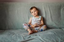 Blonde small boy with blue eyes sitting on sofa indoors — Stock Photo