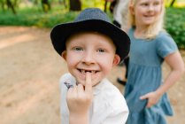 Closeup of a young boy pointing to the gap in his front teeth — Stock Photo