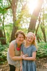 Em linha reta no retrato de uma mãe e filha na floresta — Fotografia de Stock