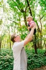 Vista de perto de um pai levantando seu bebê no ar — Fotografia de Stock