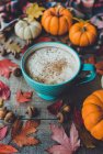 Pumpkin spice latte on wooden table with leaves and pumpkins. — Stock Photo