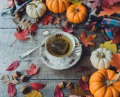 Sobre la cabeza de la taza de té en la mesa de madera con la decoración de otoño. - foto de stock