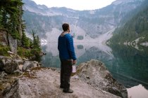 Чоловік стоїть поруч з альпійським озером в каскадах — стокове фото