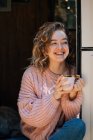 Donna che beve caffè in porta di rimorchio e sorride. — Foto stock