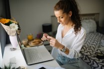 Woman sitting at her working desk and looking at the card — Stock Photo