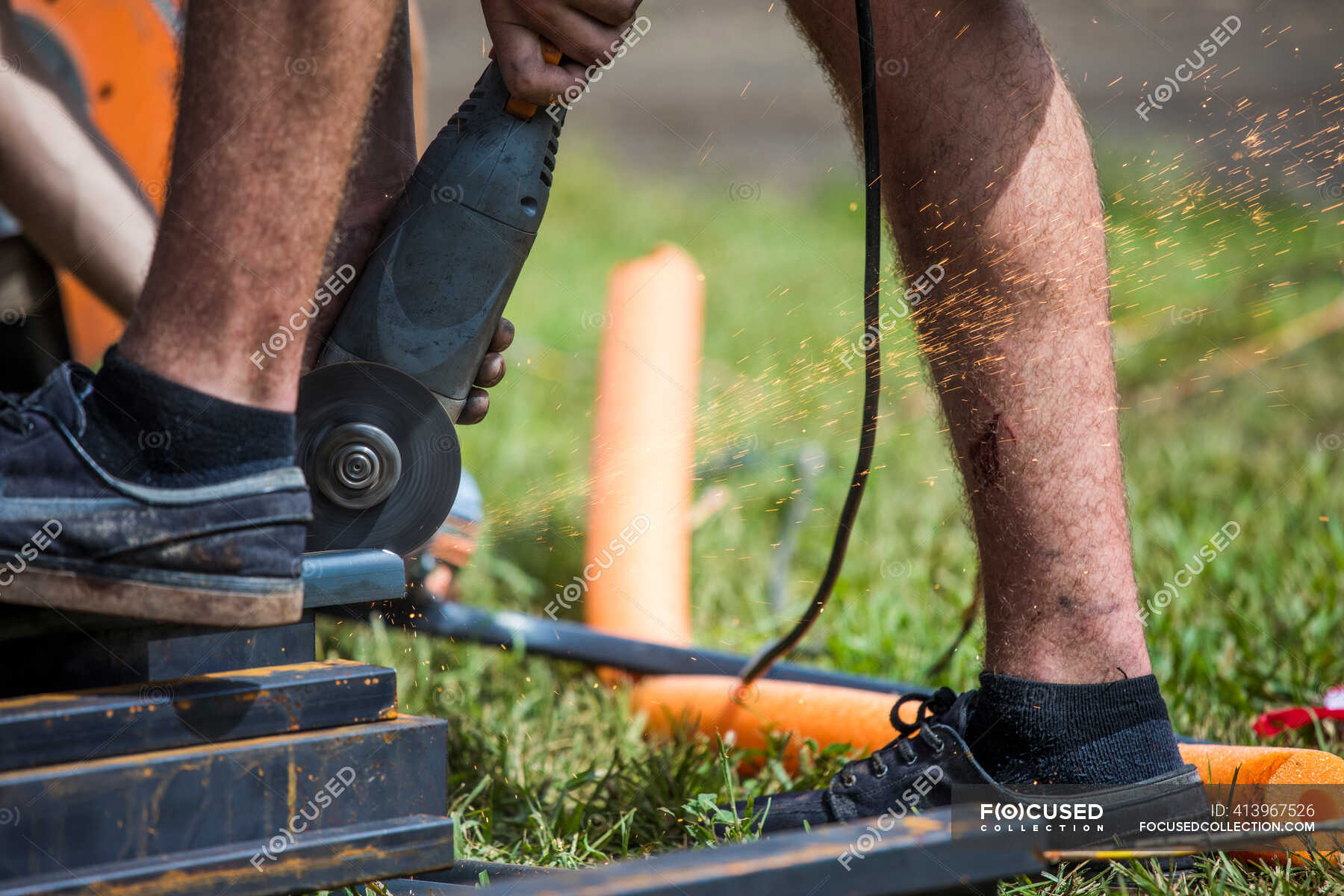 worker-using-angle-grinder-to-cut-steel-bare-safe-stock-photo