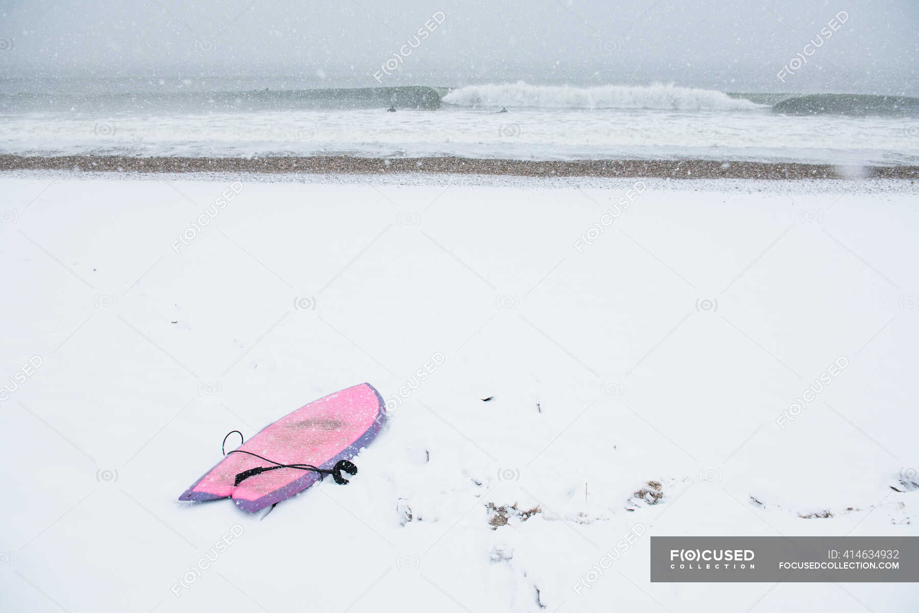 Pink surfboard on snow covered beach — united, nature Stock Photo