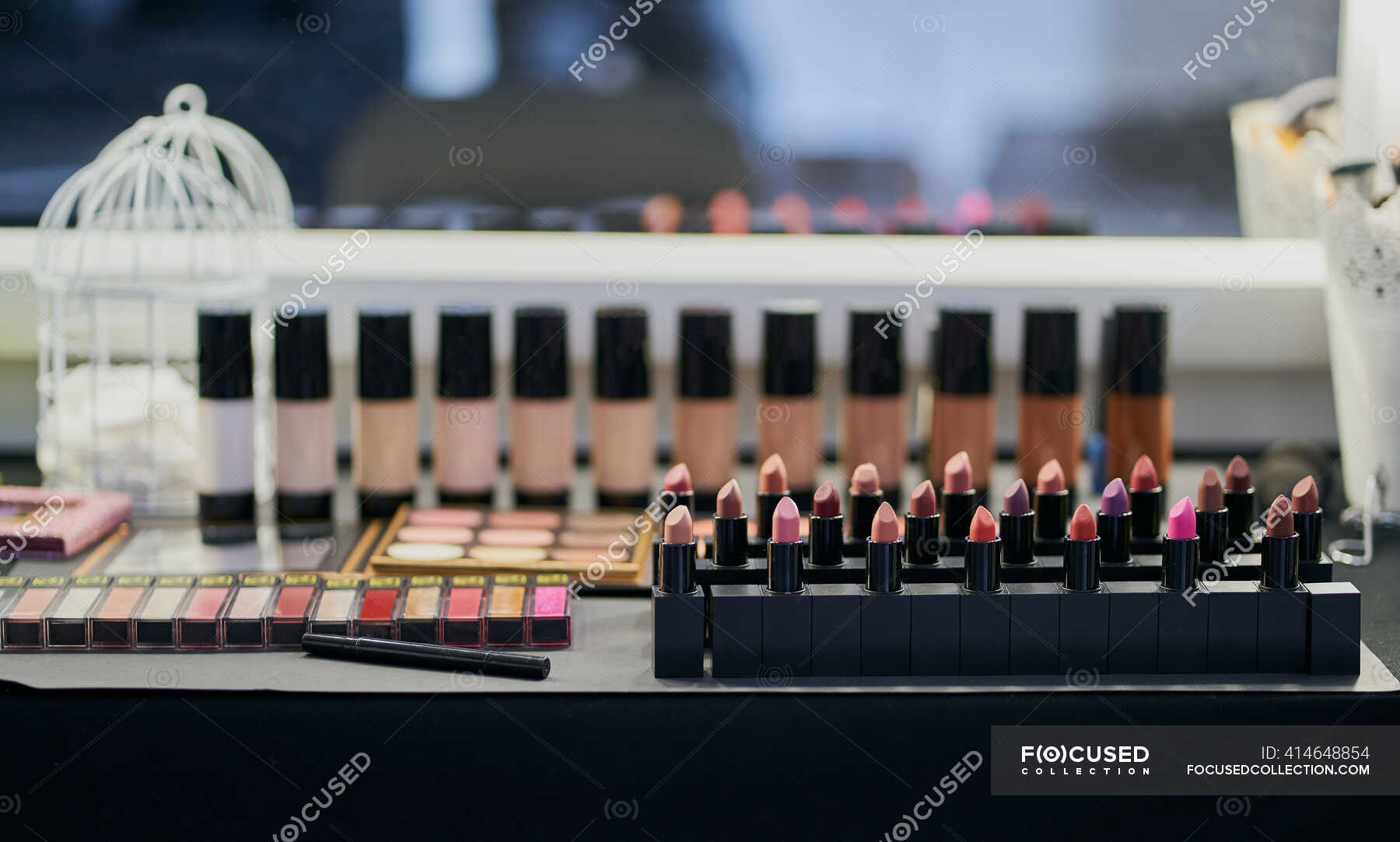 Makeup palettes, lipstick and foundation in a dressing table — cosmetic, occupation Stock