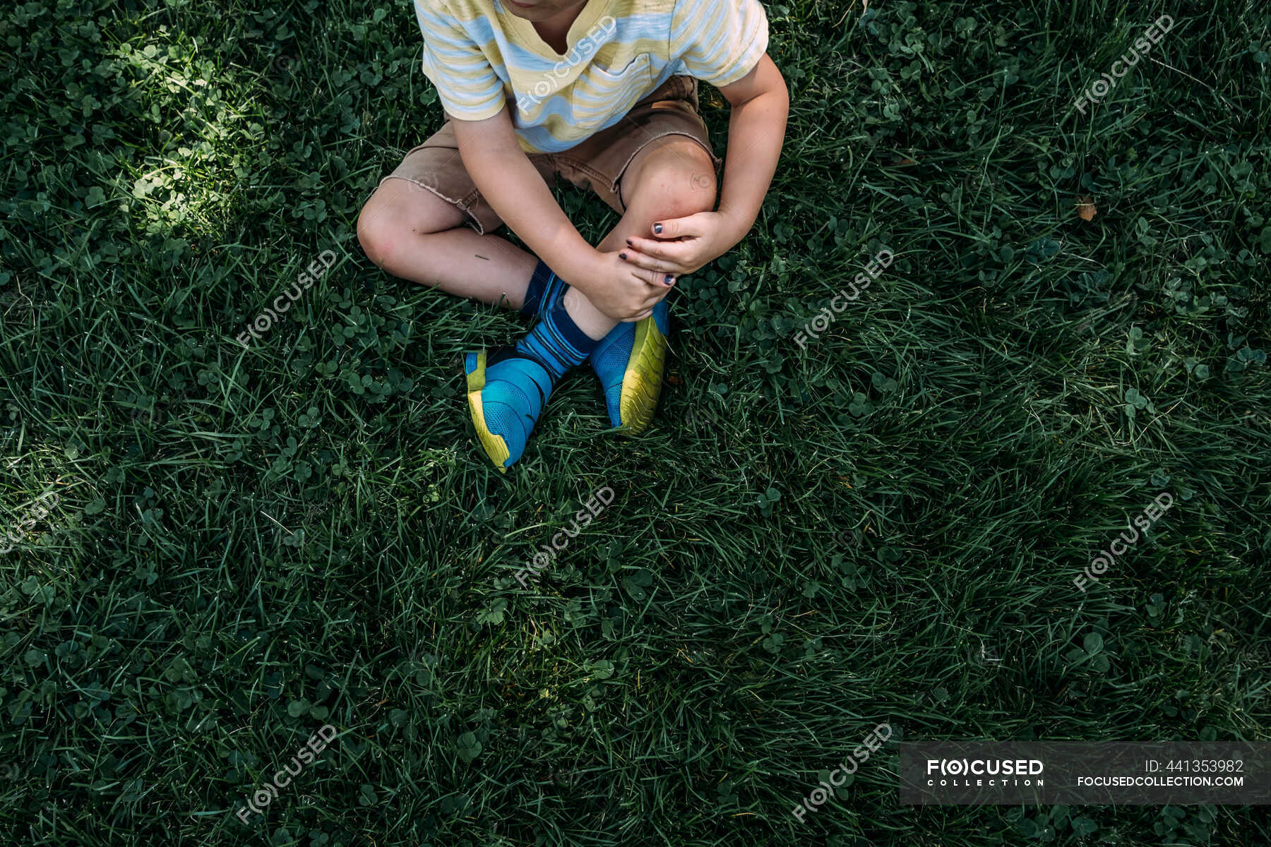 Young boy sitting in the grass on a sunny day — preschool ...