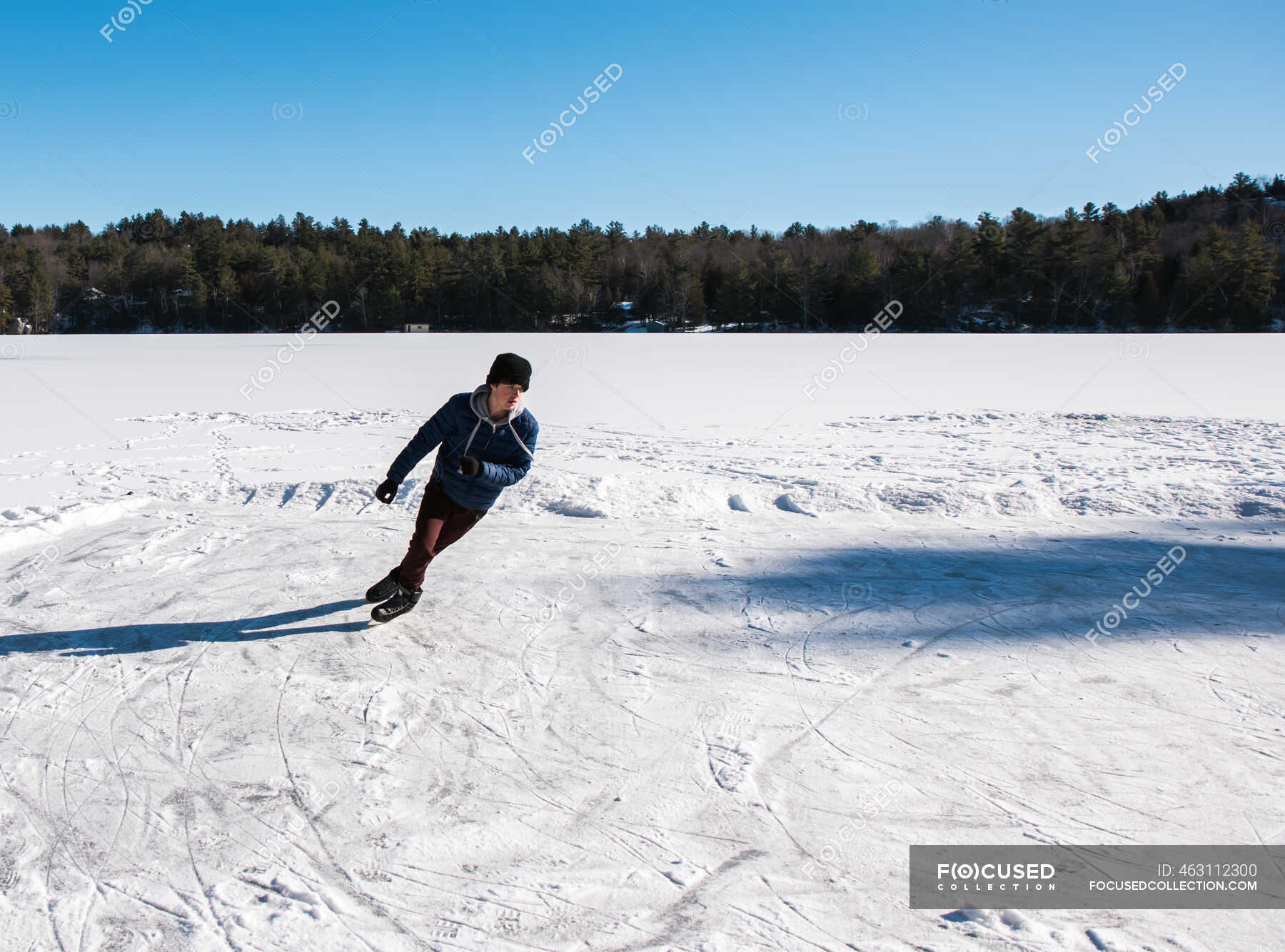 Teen Boy Eislaufen auf einem zugefrorenen See an einem Wintertag in