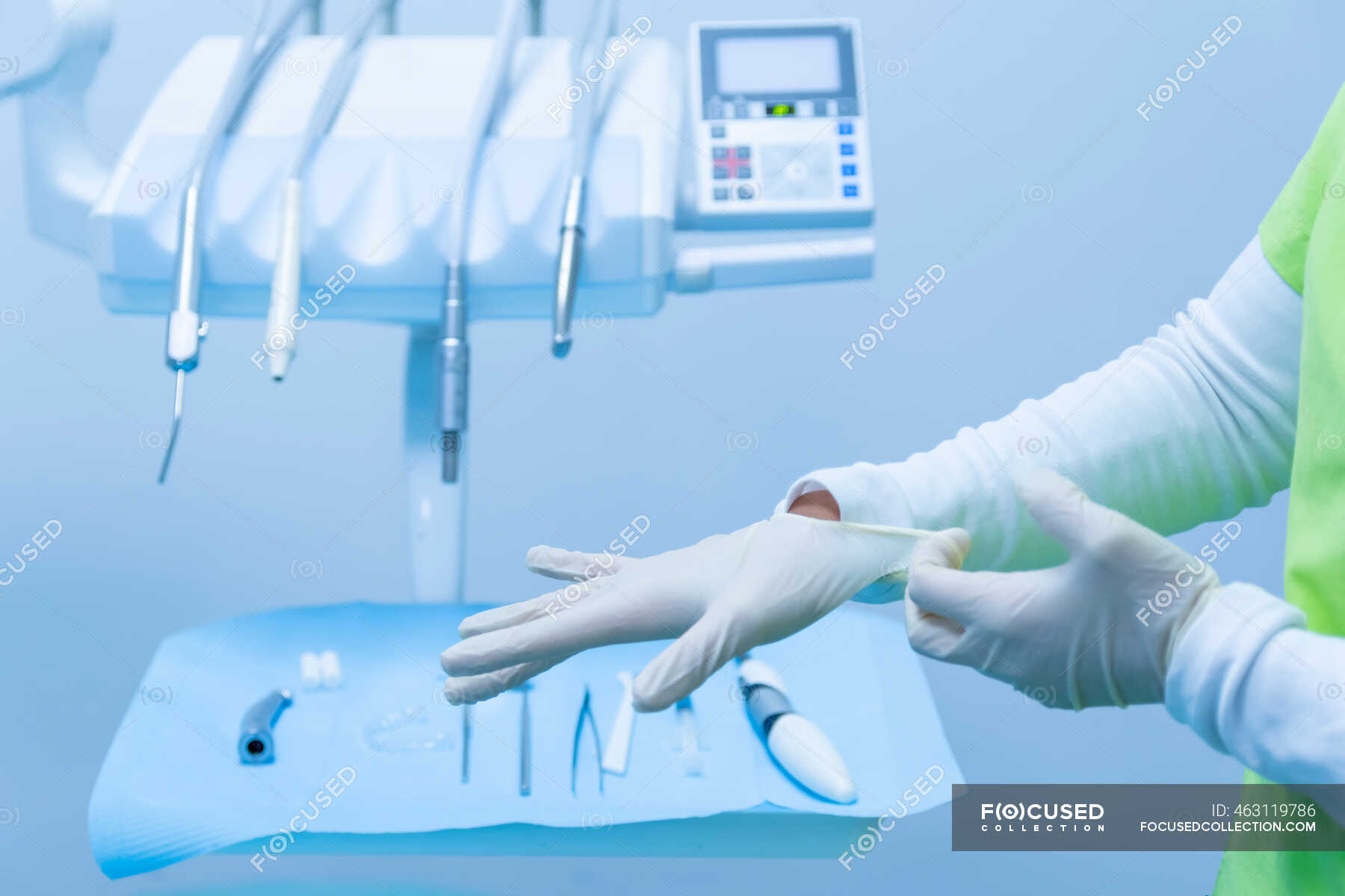 Dentist putting gloves on her hands in a dental clinic — operating