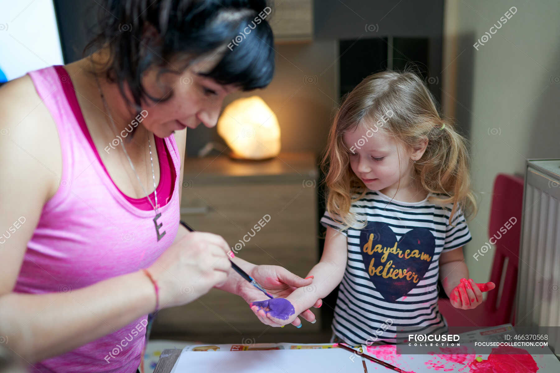 Cute little girl with teacher painting in kindergarden — elementary ...