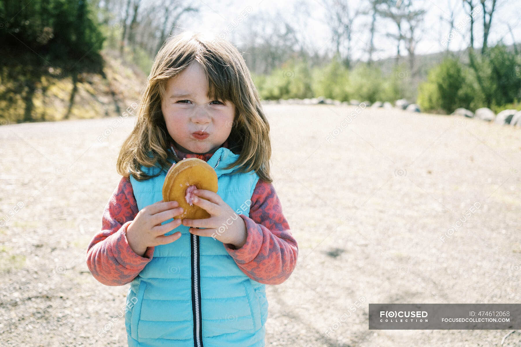 a-little-girl-with-a-pretend-mean-face-posing-with-her-donut-in-hand