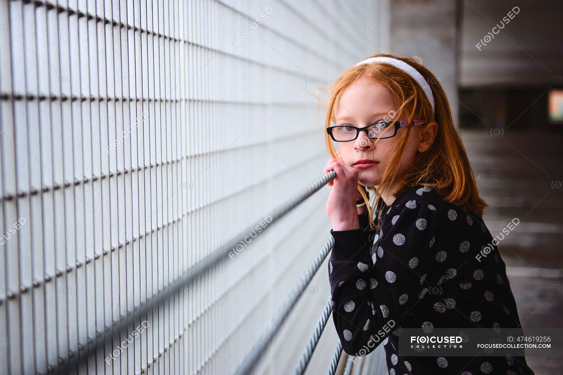 Sad lonely tween girl with red hair in parking garage. — urban, serious ...