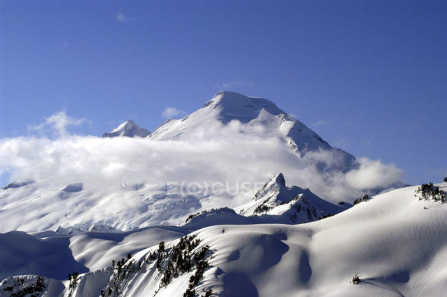 Wolken umgeben Gipfel der felsigen Berge — Stockfoto