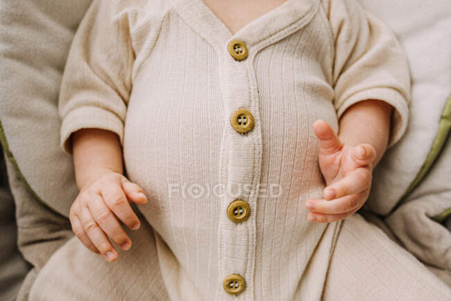 Großaufnahme eines großen vollen Babybauchs in cremefarbenem Outfit mit Knöpfen — Stockfoto