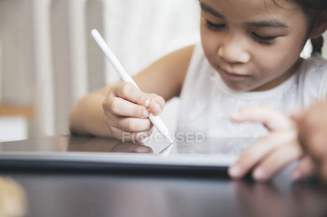 Kleines Mädchen mit Tablet und Stift lernt online zeichnen — Stockfoto