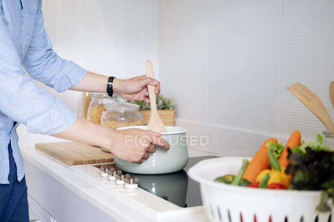 Hombre preparando comida deliciosa y saludable en la cocina casera. - foto de stock