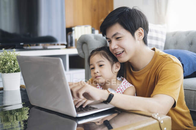 Молодой человек и школьница, работающие дома и электронного обучения — стоковое фото