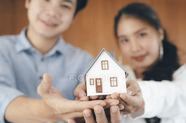 Young couple showing house model. — Stock Photo