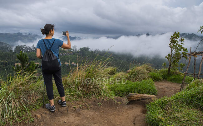 Женщина, поднимающаяся на вершину вершины Адмы рядом с Эллой в Шри-Ланке — стоковое фото