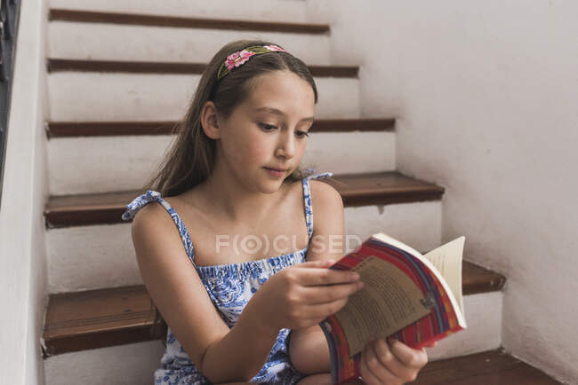 Linda niña leyendo una historia - foto de stock